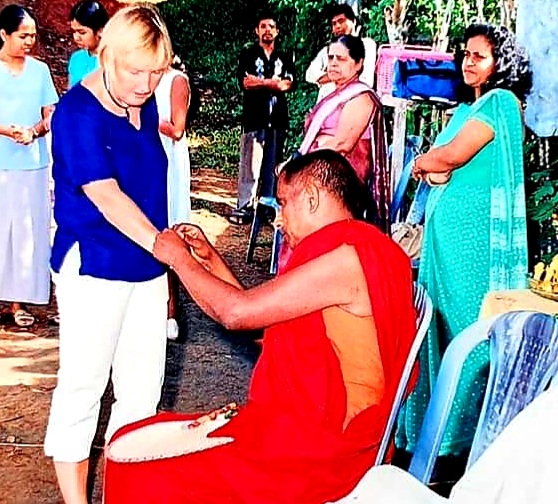 receiving a bracelet after being blessed by a Buddhist monk