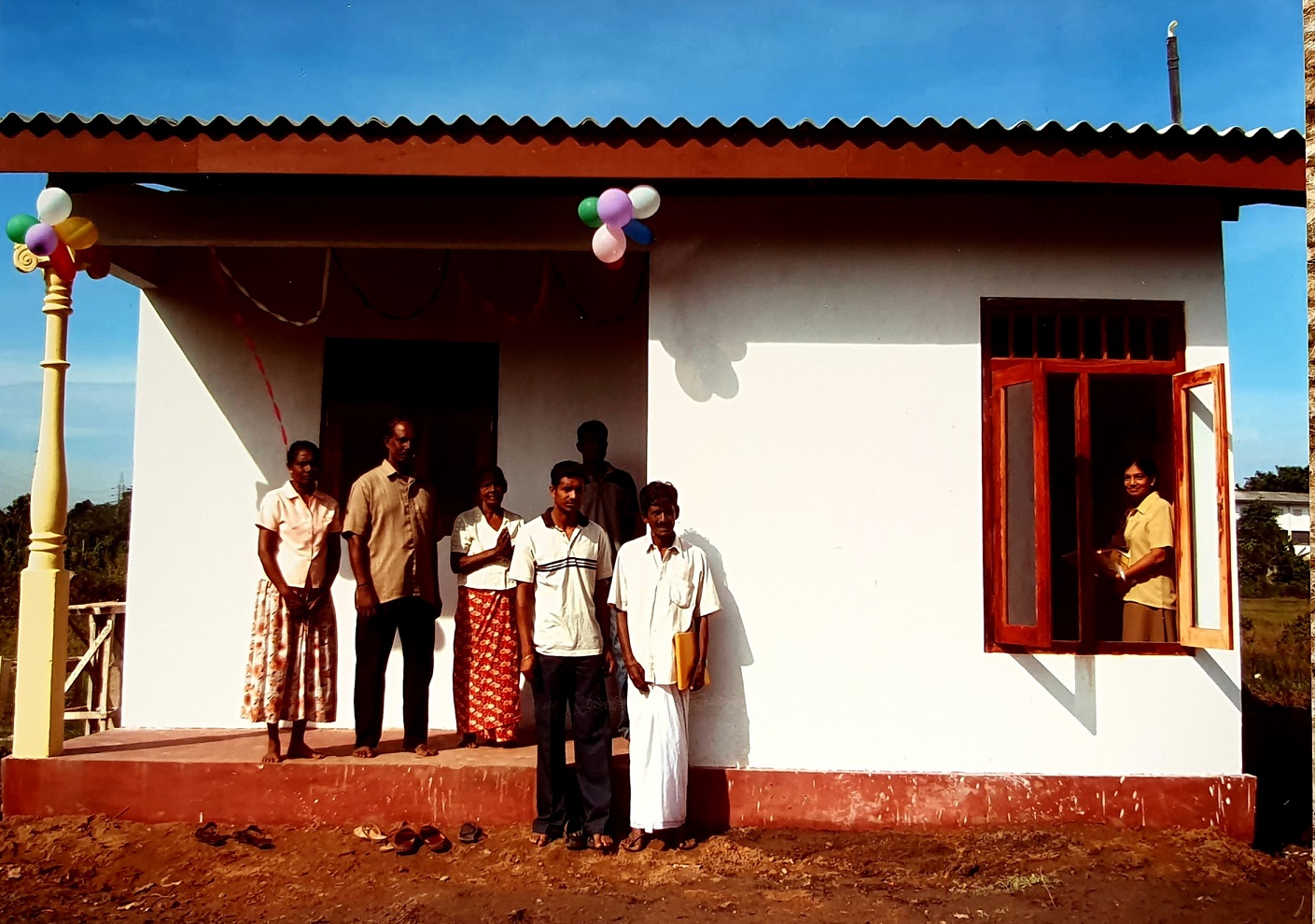 Sri Lankan family outside of their new house